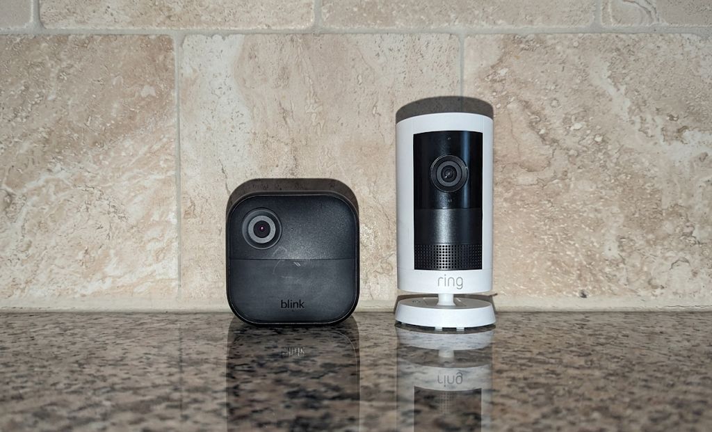 Ring Outdoor Cam Pro and Blink Outdoor 4 side by side on a kitchen counter