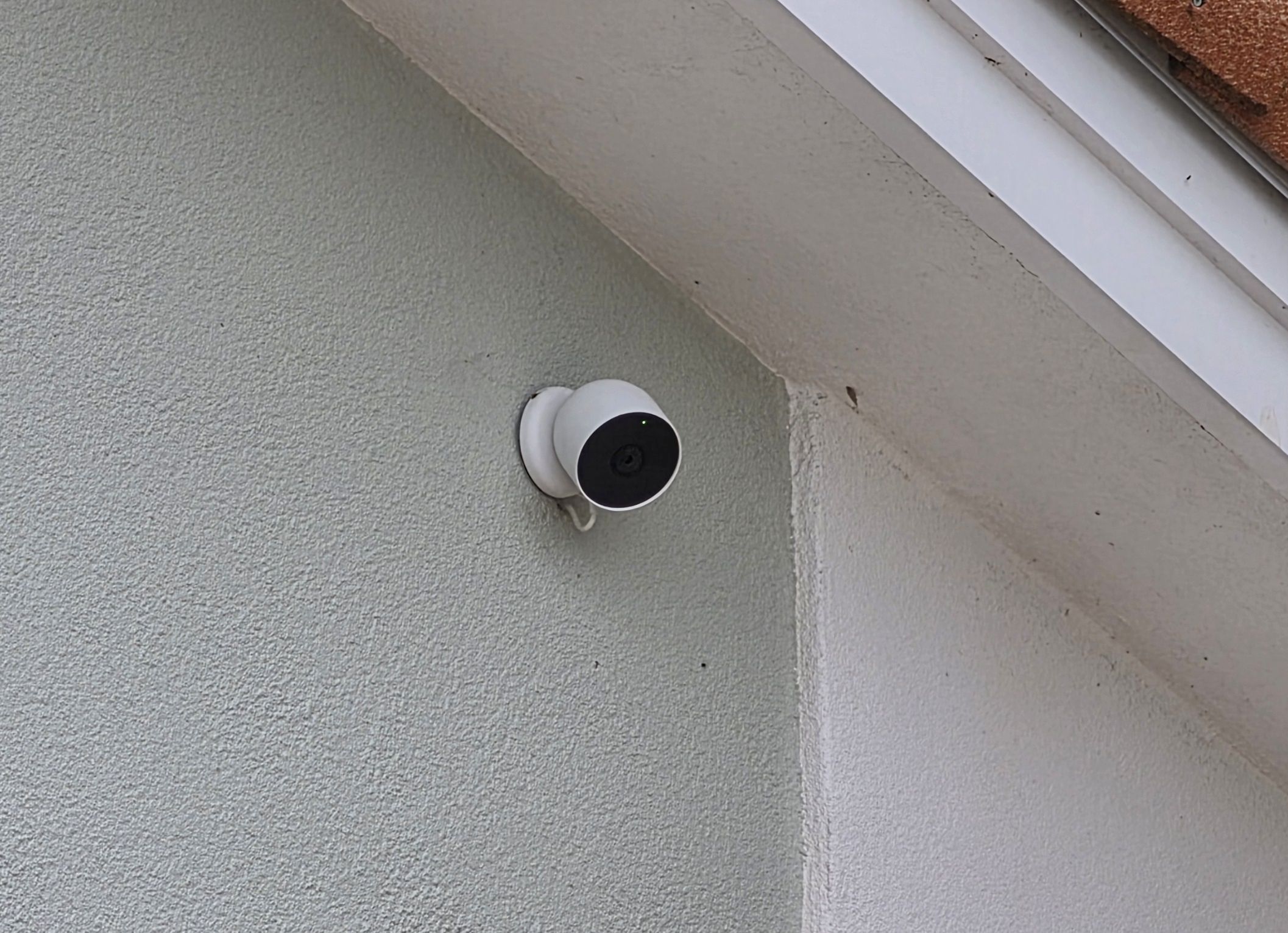 Google Nest Cam mounted on exterior wall under eave