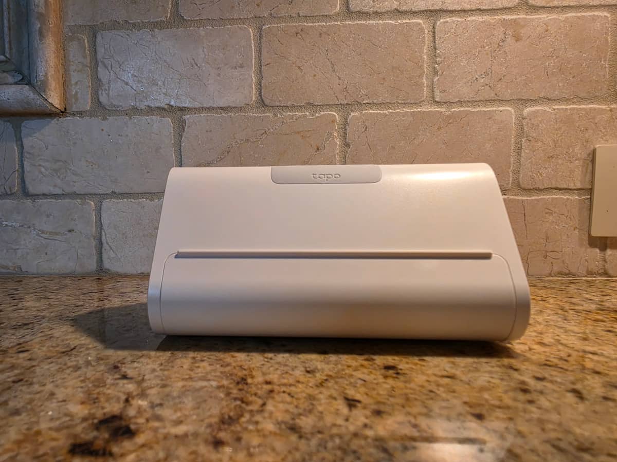 Front view of the TP-Link Tapo H500 Smart HomeBase on a countertop showing the top control buttons and lower tablet stand groove